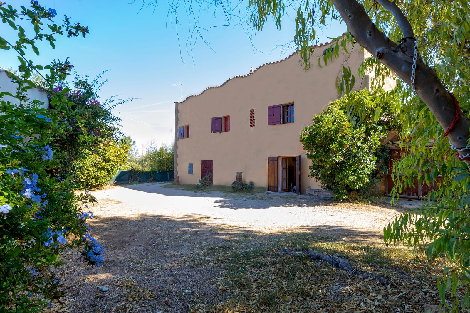 La facciata di Villa del Conte tra gli alberi del giardino
