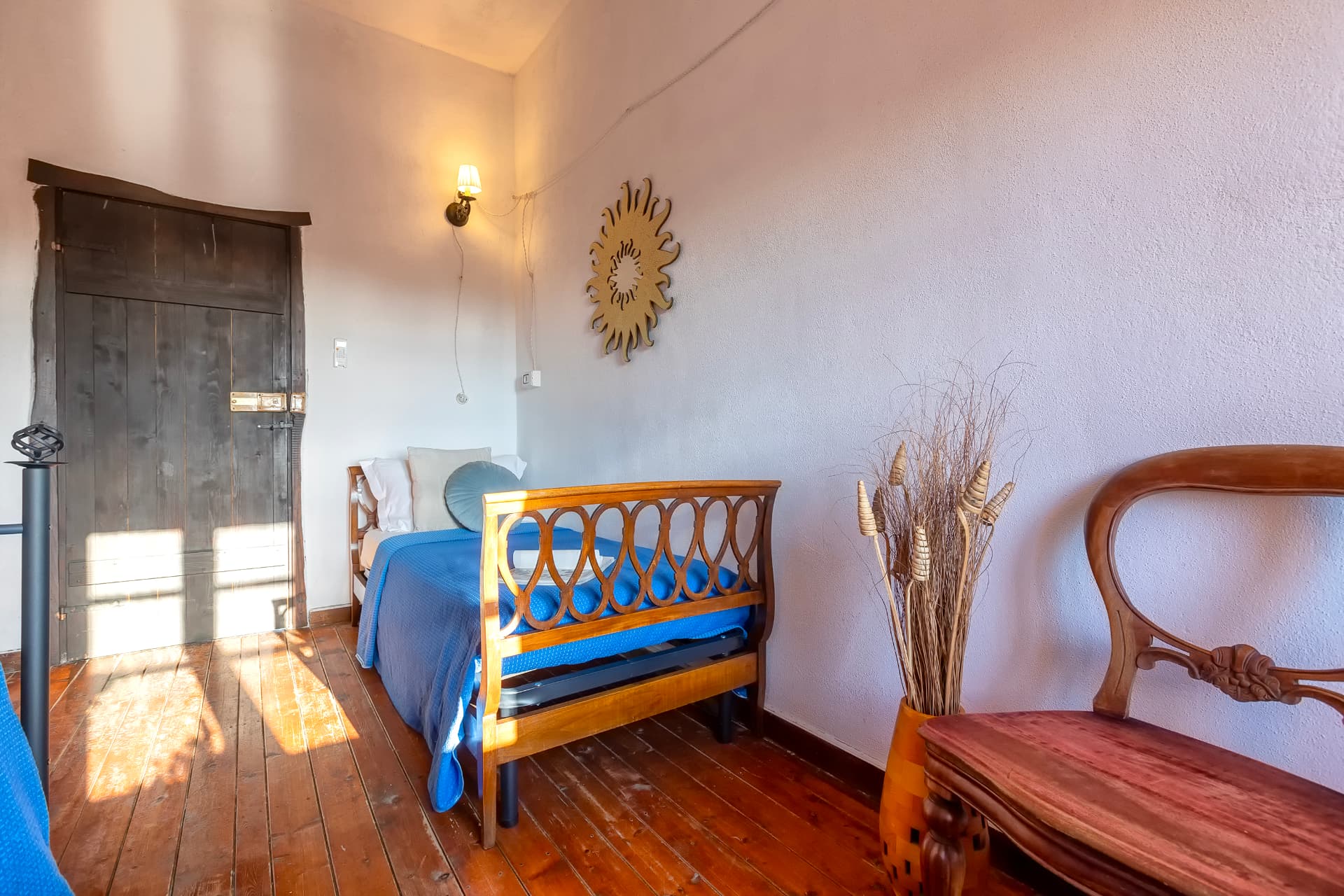 Camera con letto in legno e porta antica