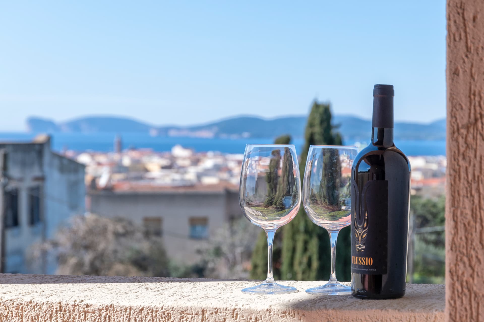 Vino e calici davanti al panorama di Alghero