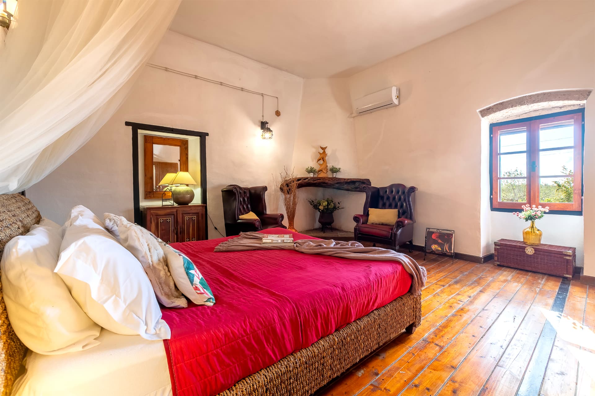 Ampia camera matrimoniale con letto rosso e camino