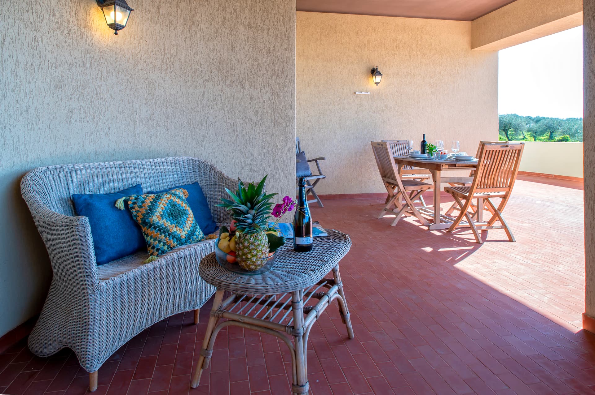 Il salotto in vimini e la zona pranzo sulla terrazza coperta