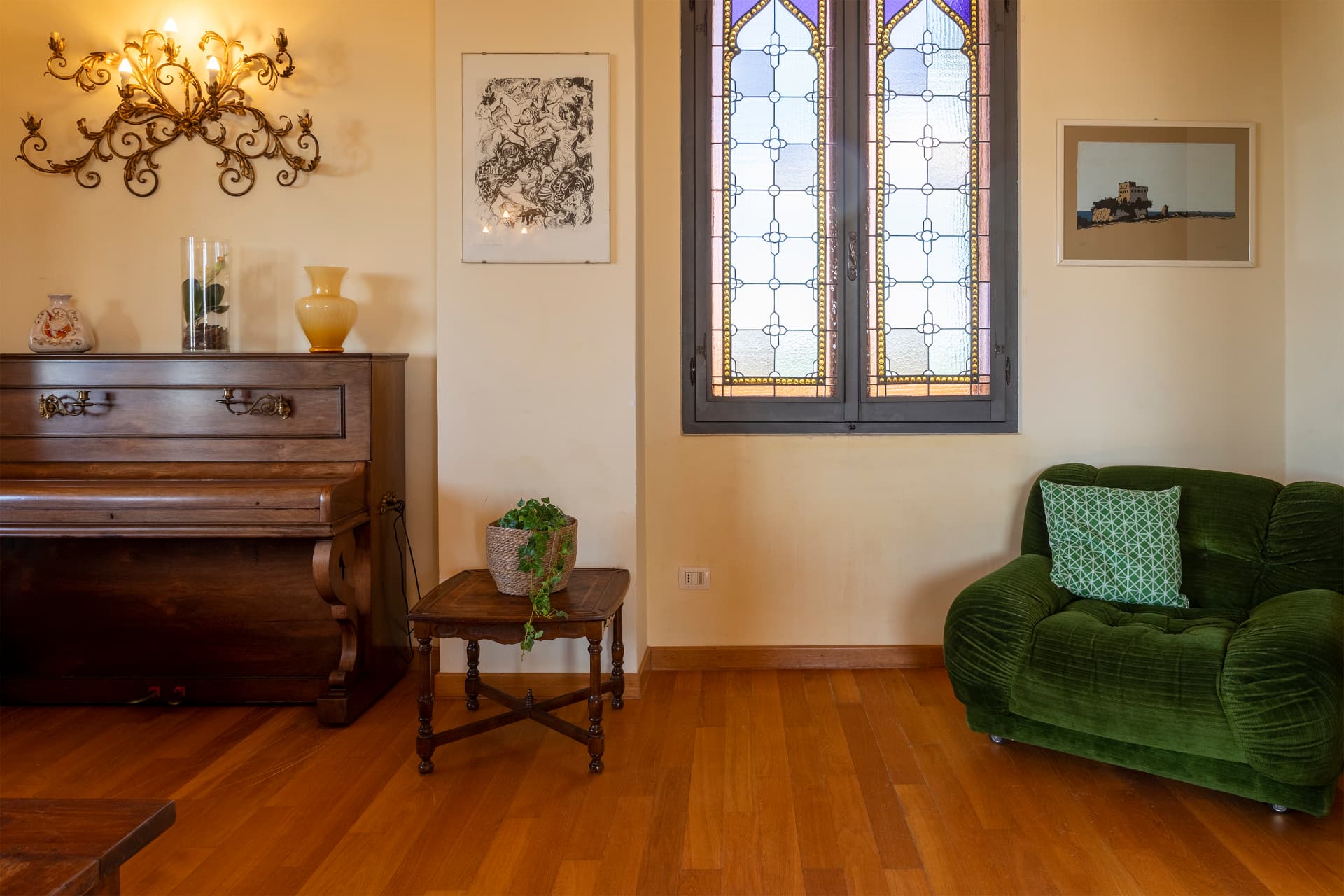 Il pianoforte e la poltrona verde nella zona living di Villa Contessa