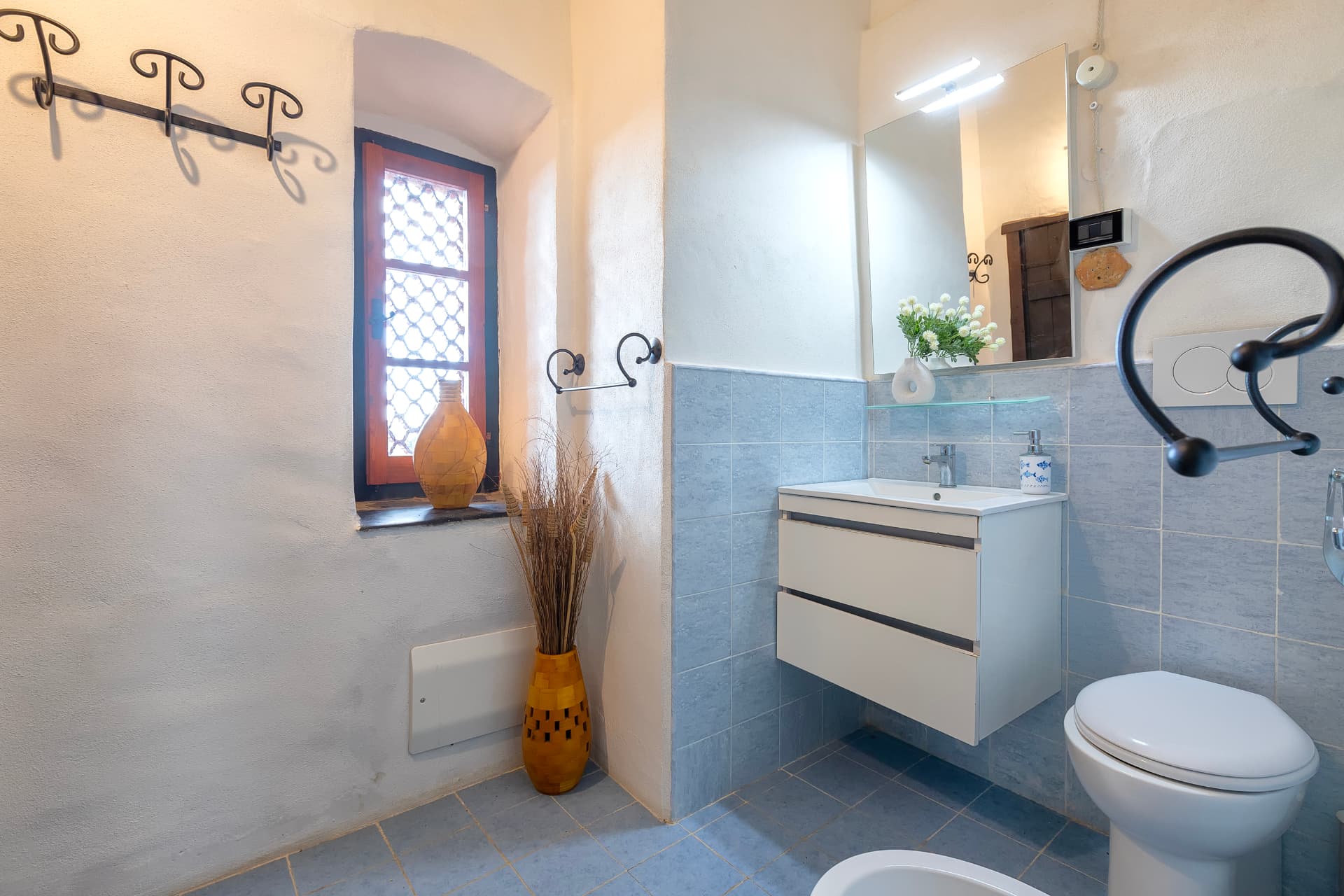Bagno con lavabo, finestra e dettagli in ferro battuto