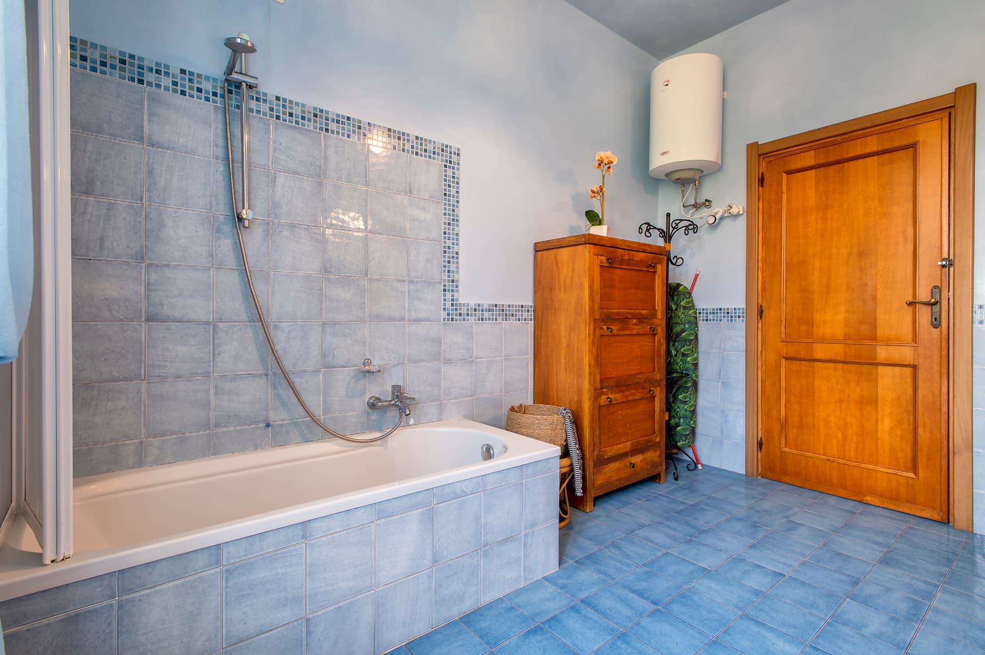 La vasca e gli arredi in legno del bagno azzurro