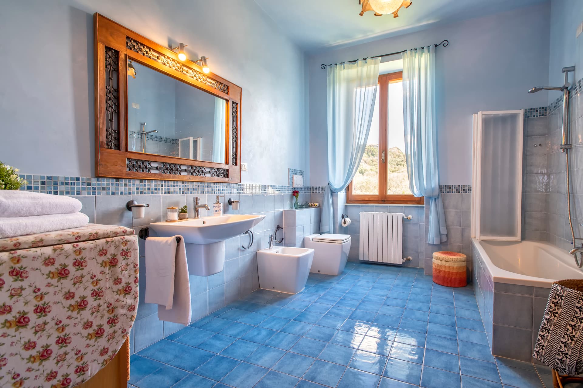 L’ampio bagno azzurro di Villa Contessa con vasca e finestra