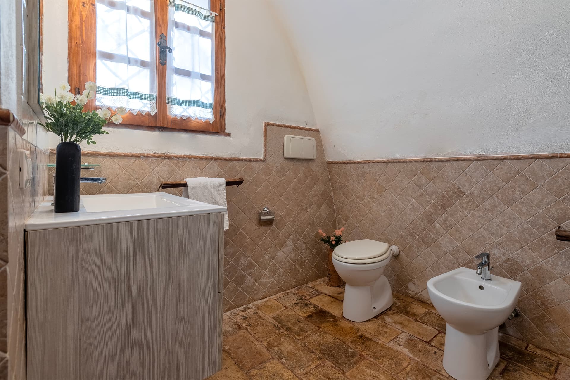 Bagno con lavabo, sanitari e finestra