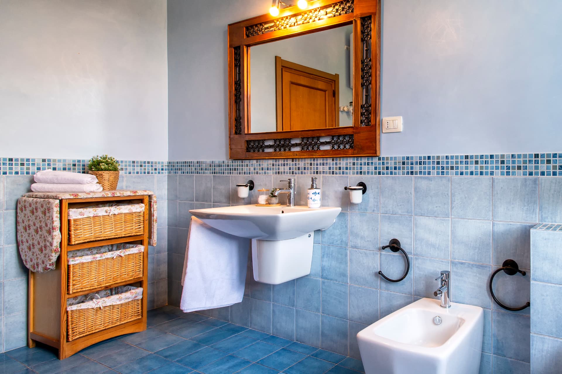 Il lavabo e lo specchio artigianale del bagno azzurro